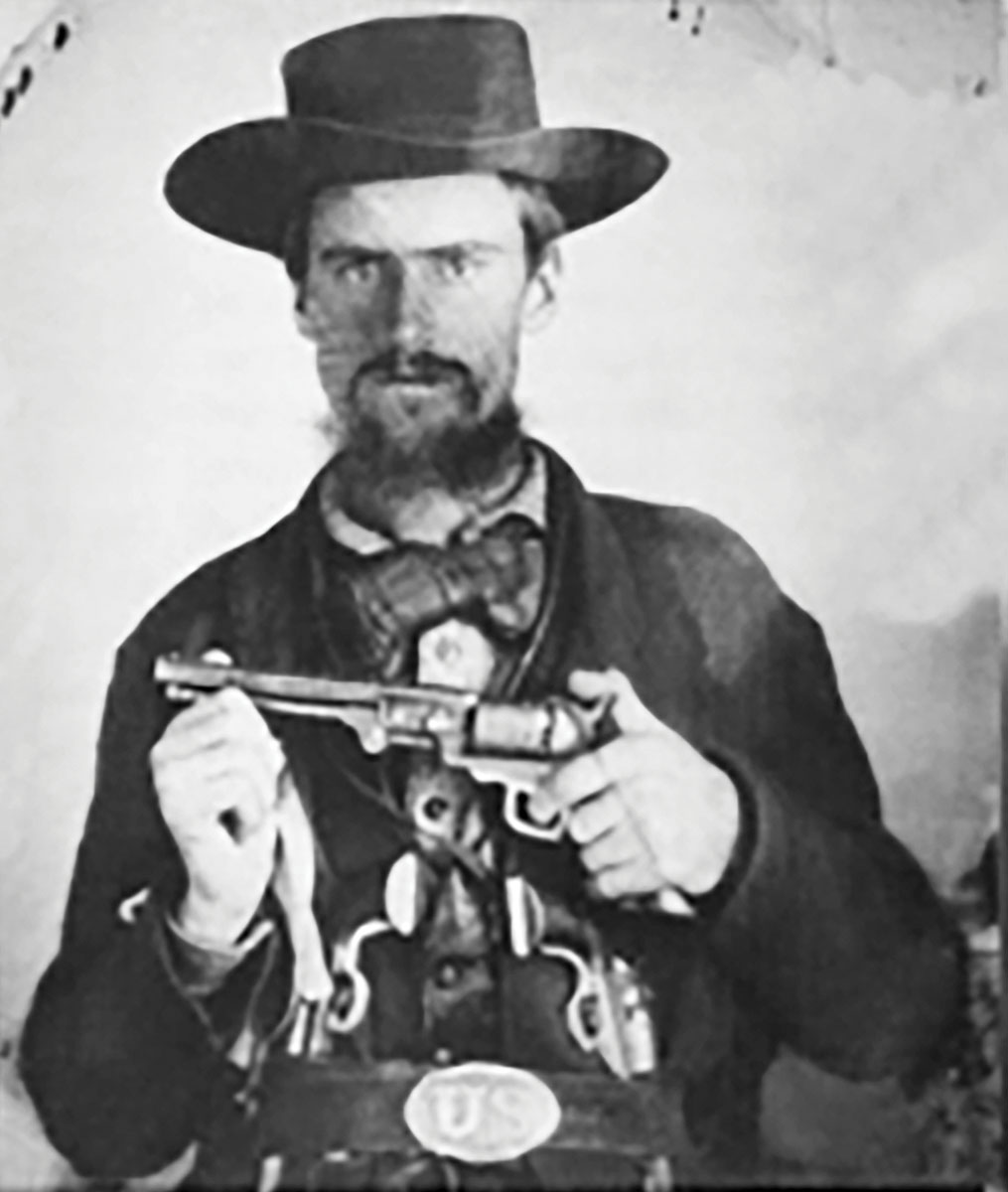 Two in his belt and one in hand, this fighter sports a U.S. belt buckle and three 1851 Colts (or  copies thereof).